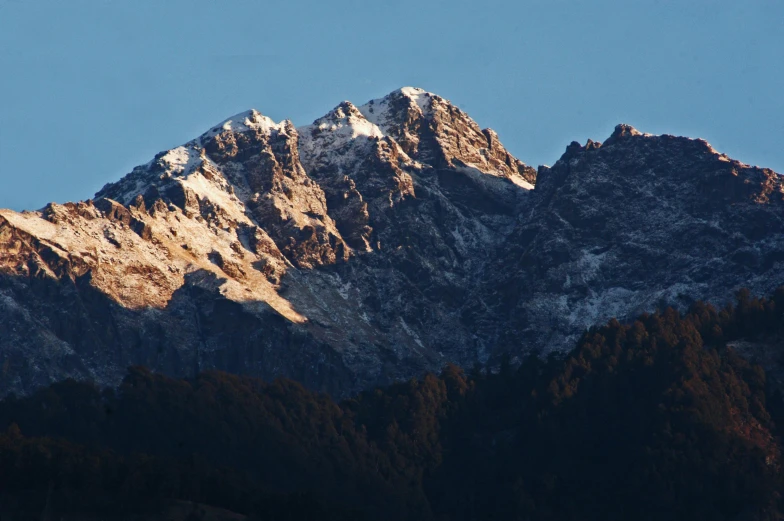 a plane flying over the top of a snow covered mountain, by Peter Churcher, pexels contest winner, sumatraism, dappled in evening light, front lit, panorama, brown