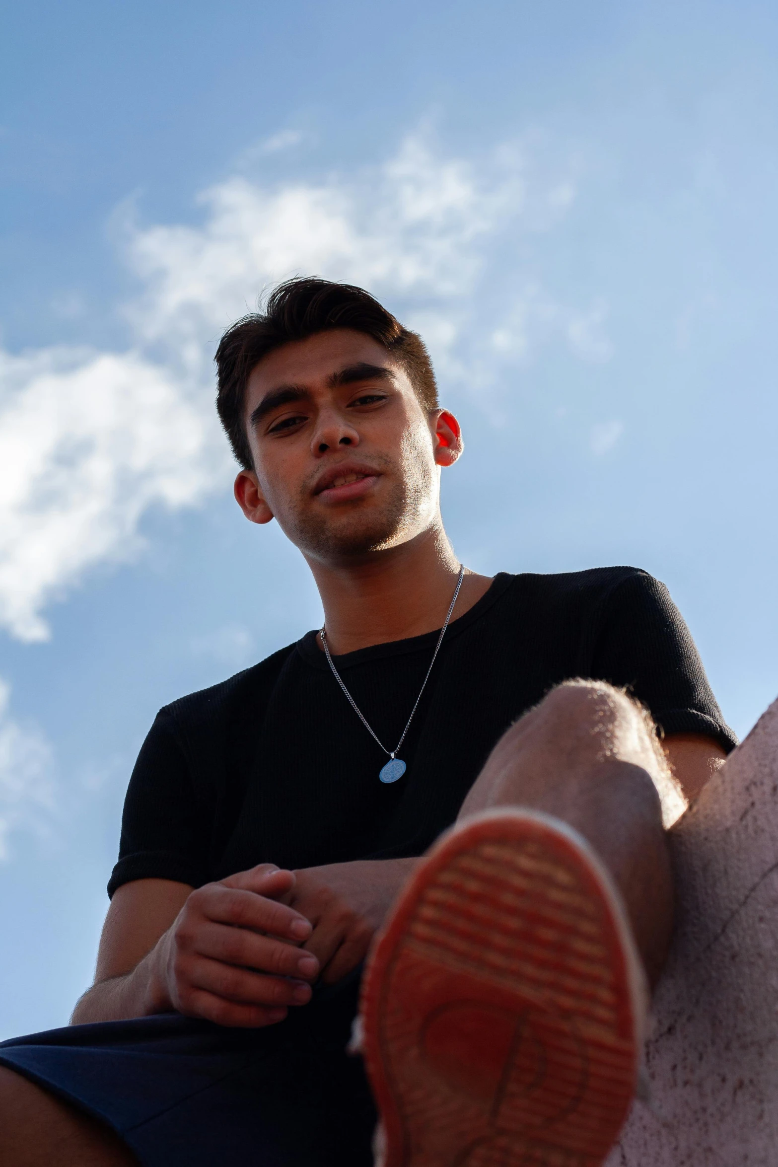 a man sitting on top of a white horse, an album cover, trending on pexels, hurufiyya, wearing a black tshirt, diego fernandez, blue sky, non binary model