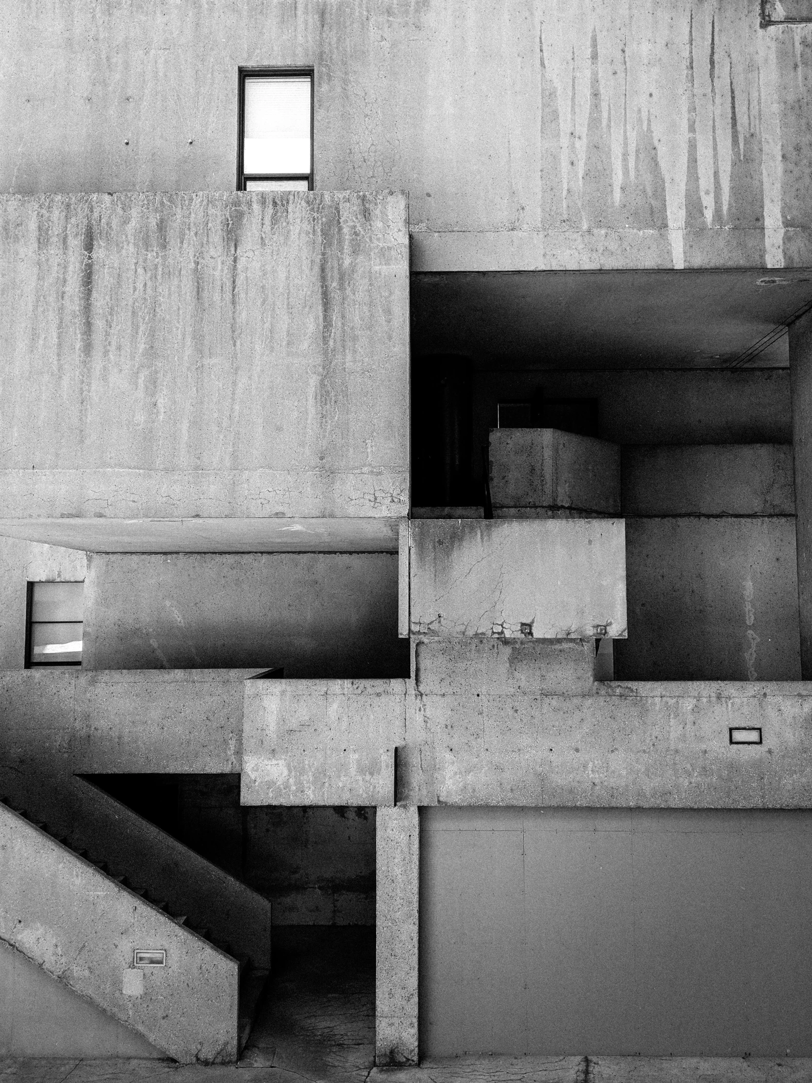 a black and white photo of a concrete building, unsplash, brutalism, complex layered composition!!, 1 9 8 5 photograph, made of concrete, inside building