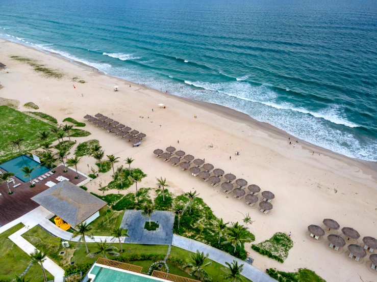 a view of a beach from a bird's eye view, infinity concentric pool, icaro carvalho, parasols, white sand beach