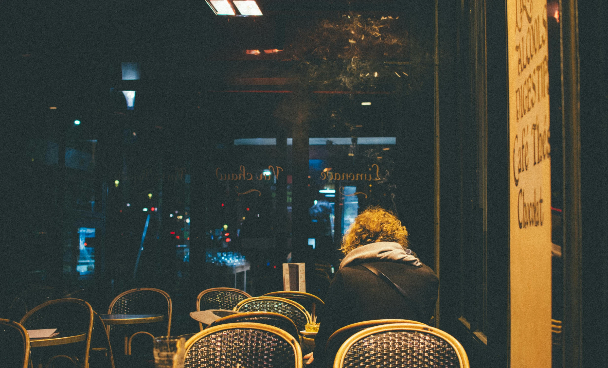 a person sitting at a table outside of a restaurant, pexels contest winner, very smoky paris bar, nighthawks, sad lonely mellow vibes, looking outside