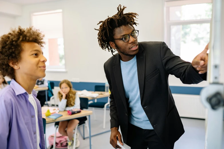 a man standing next to another man in a classroom, pexels contest winner, black teenage boy, reaching out to each other, lachlan bailey, instagram post