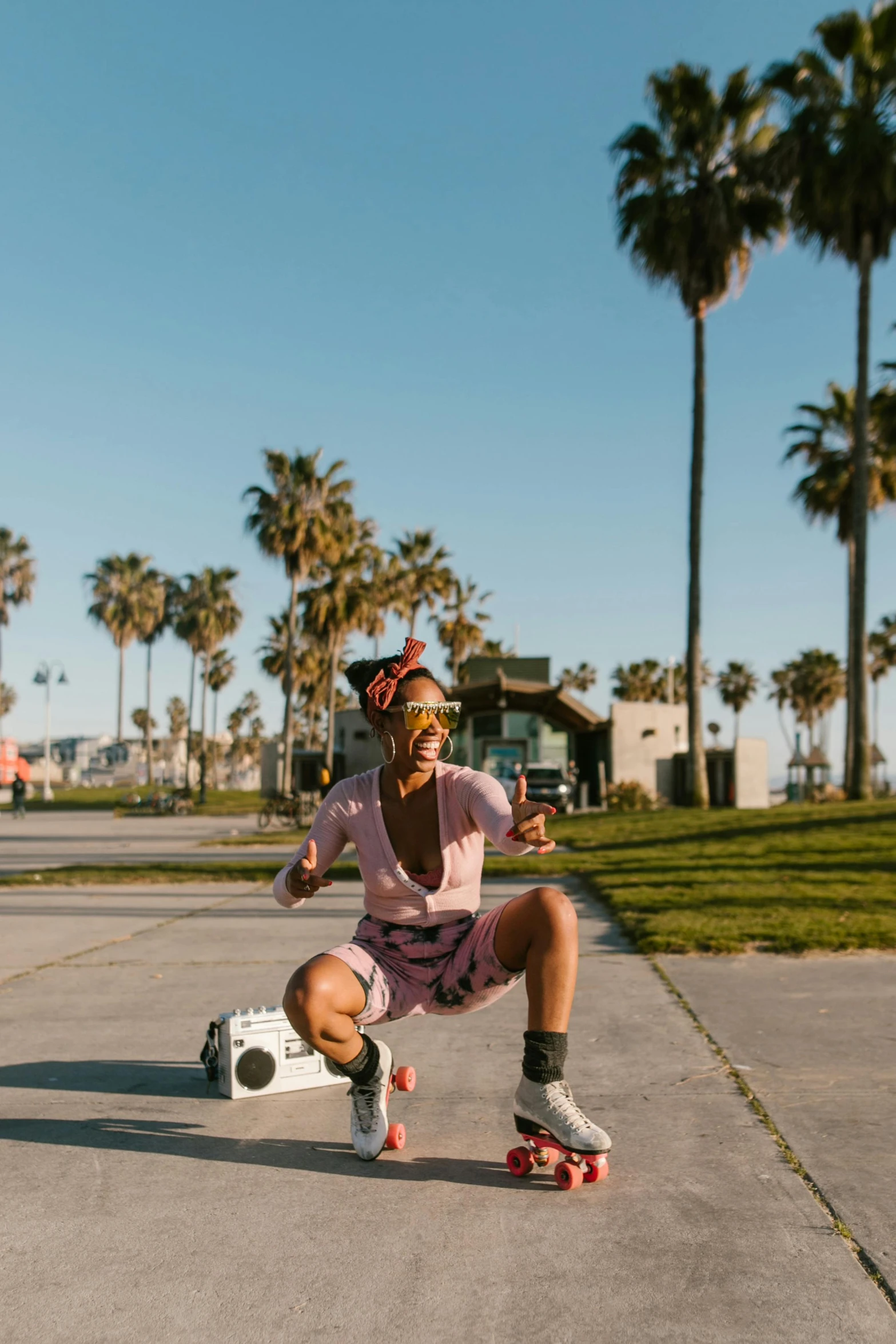 a man riding a skateboard down a sidewalk, a polaroid photo, unsplash contest winner, happening, dancing on the beach, with palm trees in the back, photo of a black woman, laughing