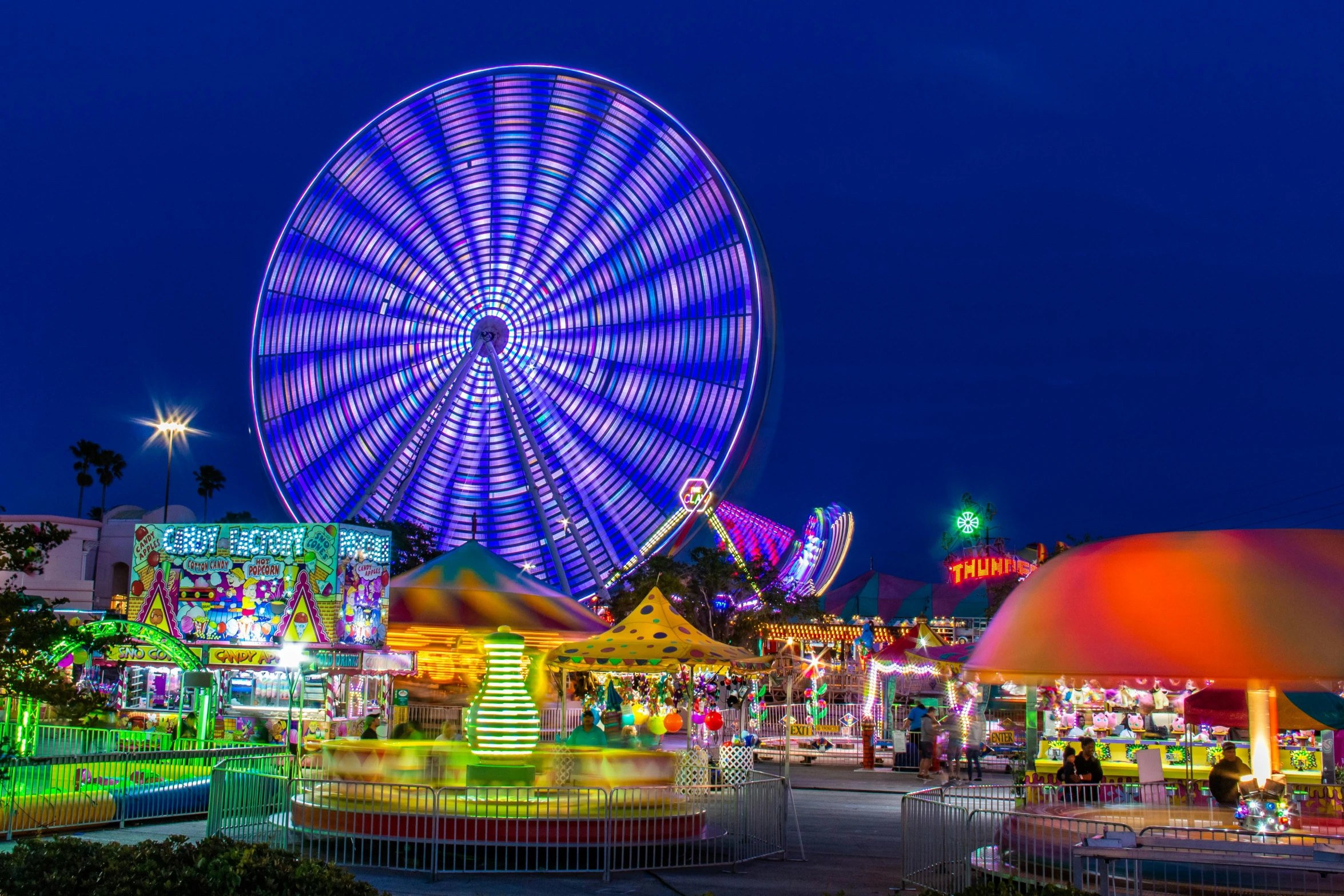 a carnival at night with a ferris wheel in the background, bright neon colours, profile image, discovery zone, new jersey