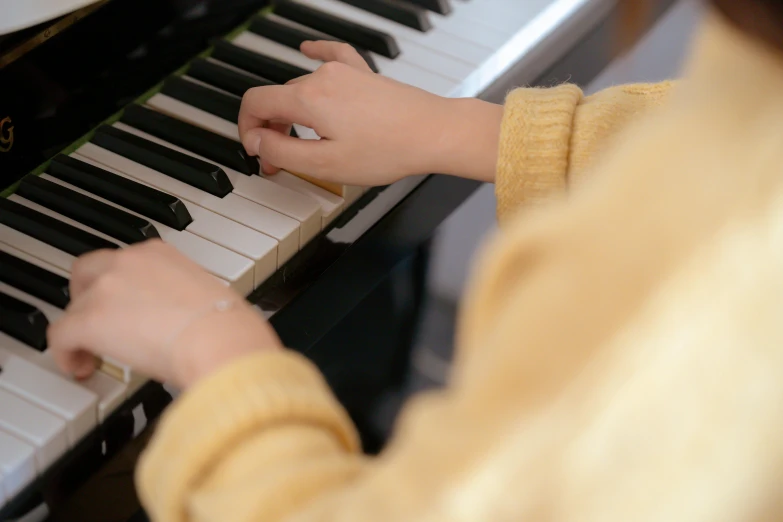 a close up of a person playing a piano, for junior, yellow, casually dressed, thumbnail