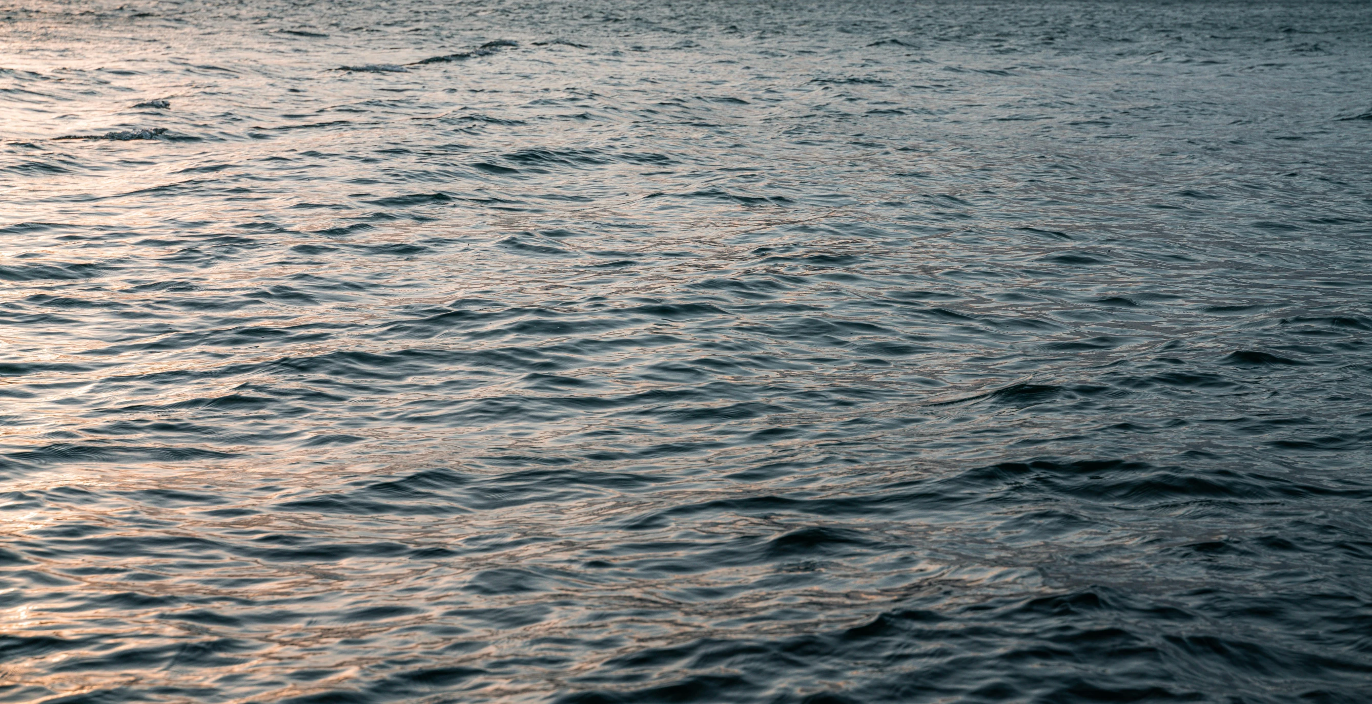 a large body of water with a boat in the distance, inspired by Elsa Bleda, hurufiyya, swirly ripples, evening sun, 8k 50mm iso 10, shot on hasselblad