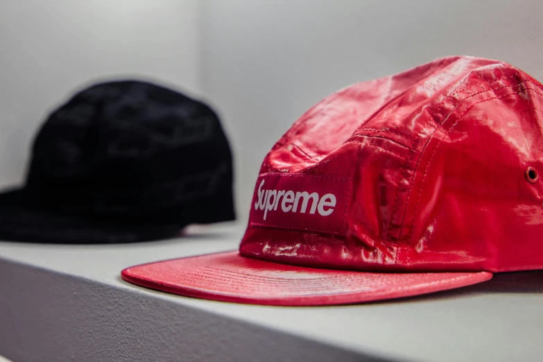 a couple of hats sitting on top of a shelf, unsplash, hyperrealism, supreme, crimson themed, metal garments, low profile