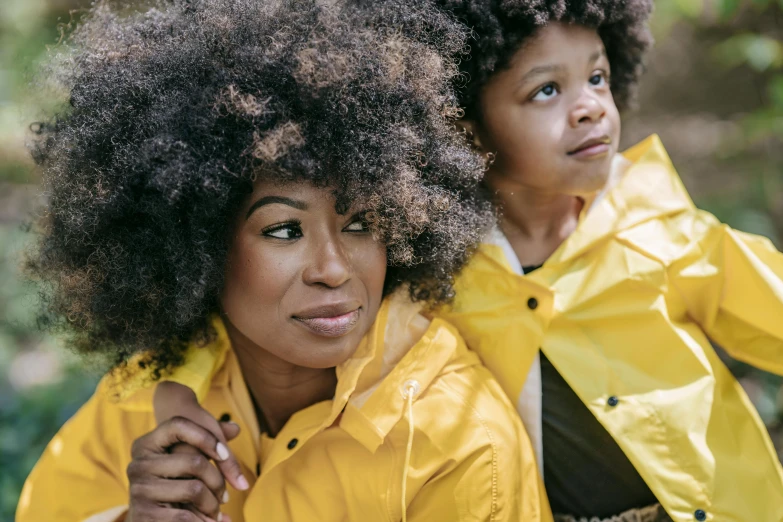 a woman and a child posing for a picture, a portrait, pexels contest winner, afrofuturism, yellow raincoat, black man with afro hair, youtube thumbnail, natural hair