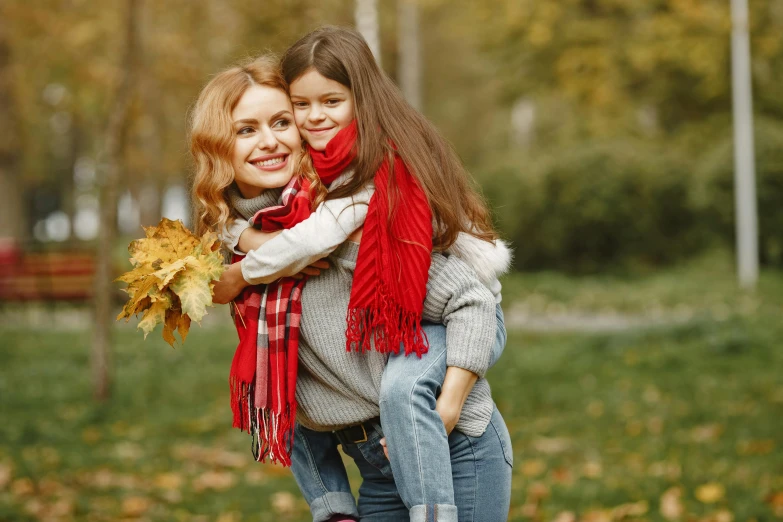 a woman carrying a little girl in her arms, a picture, by Emma Andijewska, shutterstock, fine art, red scarf, autum, square, game