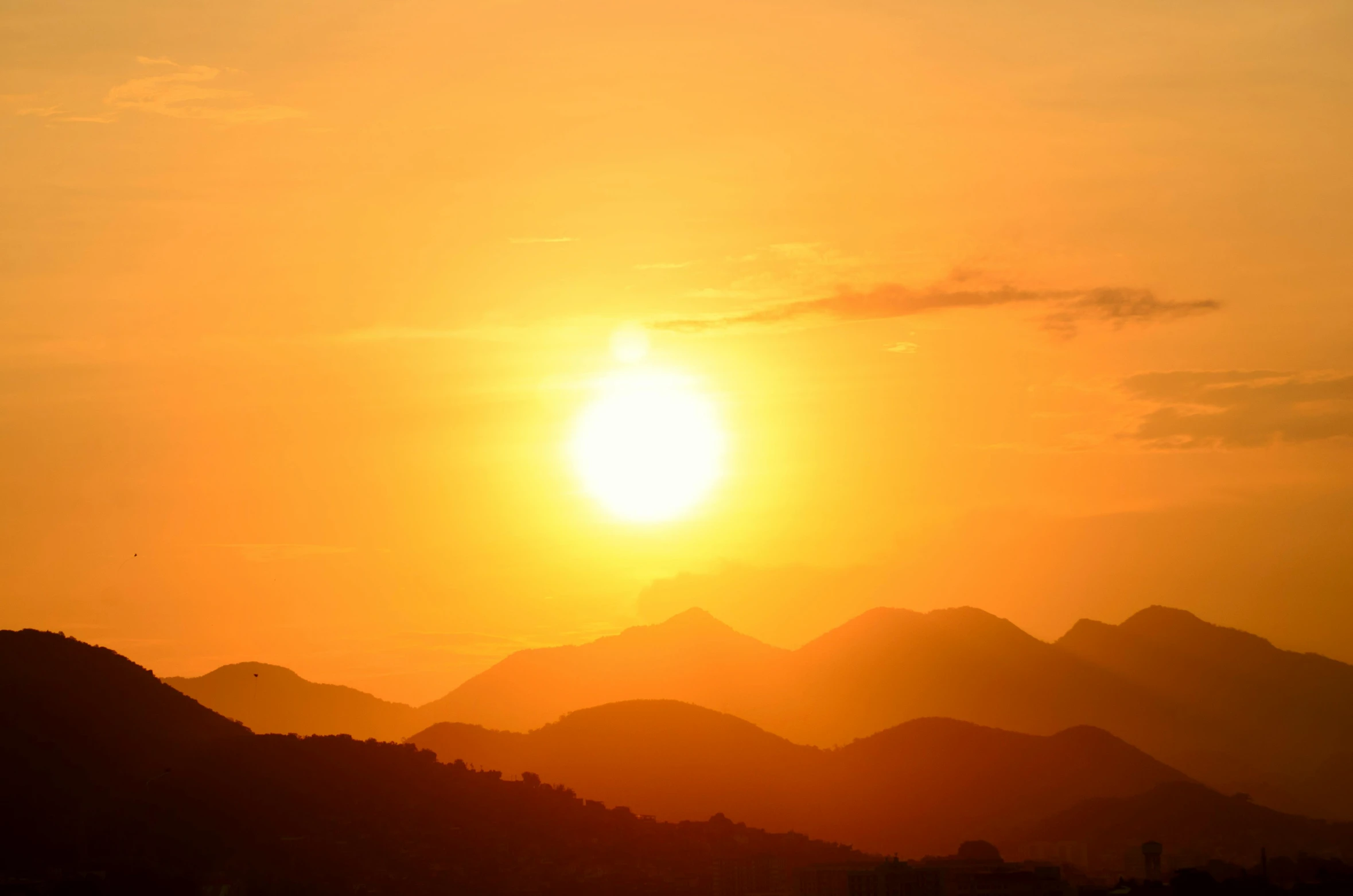 the sun is setting over a mountain range, pexels contest winner, romanticism, hot summer sun, orange yellow ethereal, suns, hot and humid