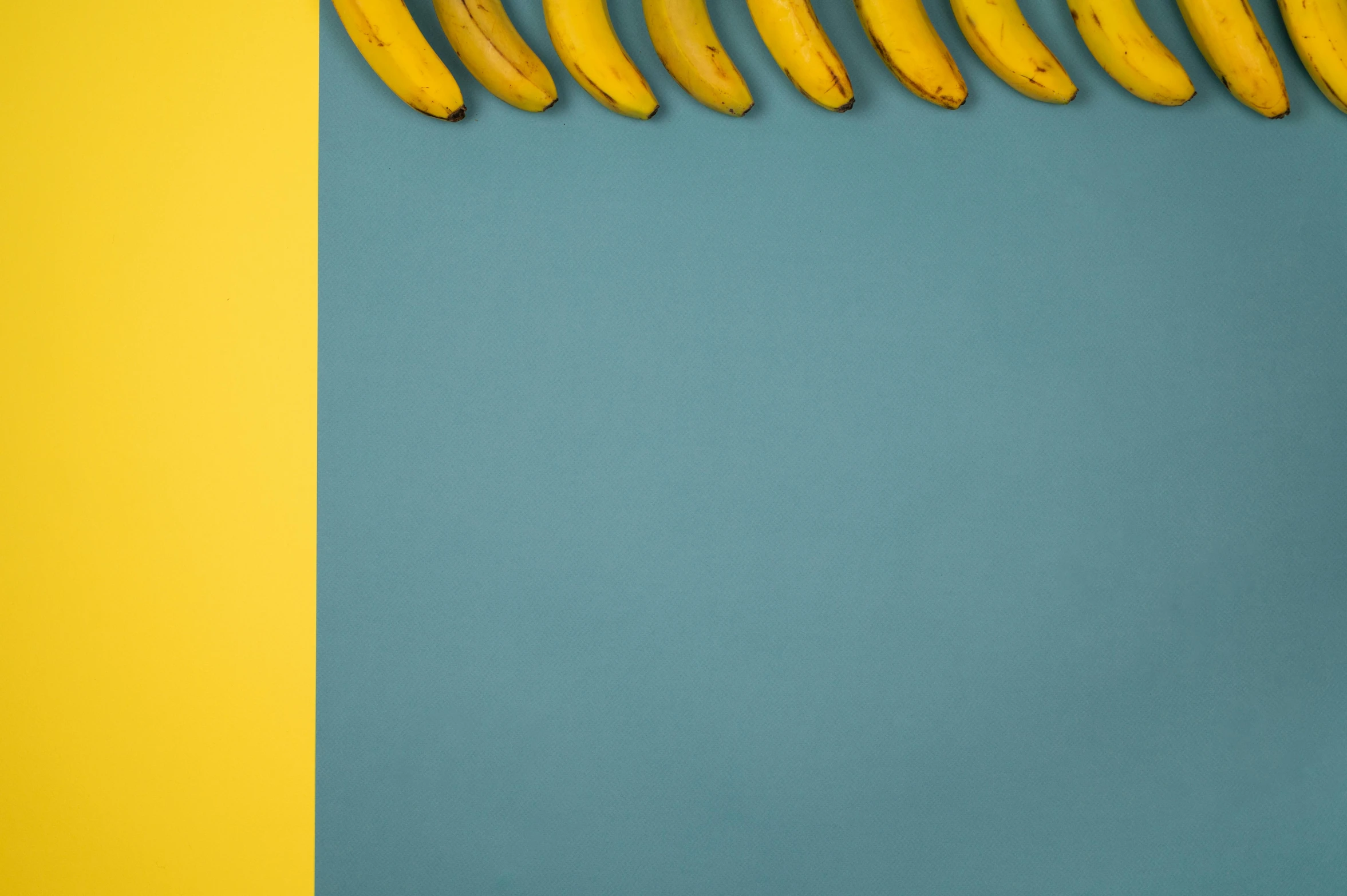 a bunch of bananas sitting on top of a blue and yellow wall, a minimalist painting, trending on pexels, background image, curves, teal paper, miscellaneous objects