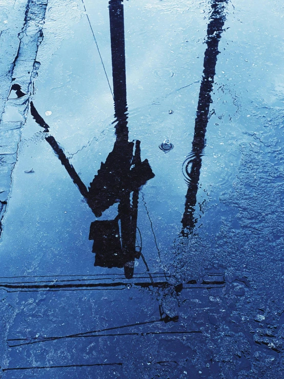 a reflection of a street light in a puddle of water, inspired by Elsa Bleda, unsplash contest winner, photorealism, telephone wires, blue liquid and snow, instagram story, machinery and wires
