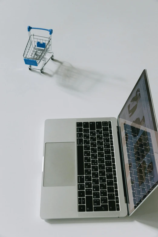 a laptop computer sitting on top of a white table, shopping cart, show from below, promo image, cryptocurrency