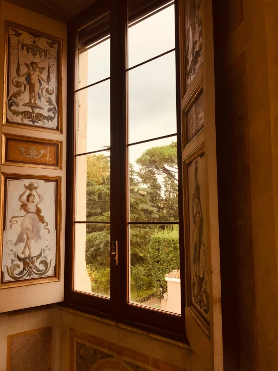 a picture hanging on a wall next to a window, inspired by Pietro da Cortona, low quality photo, ocher details, tattooed, tourist photo