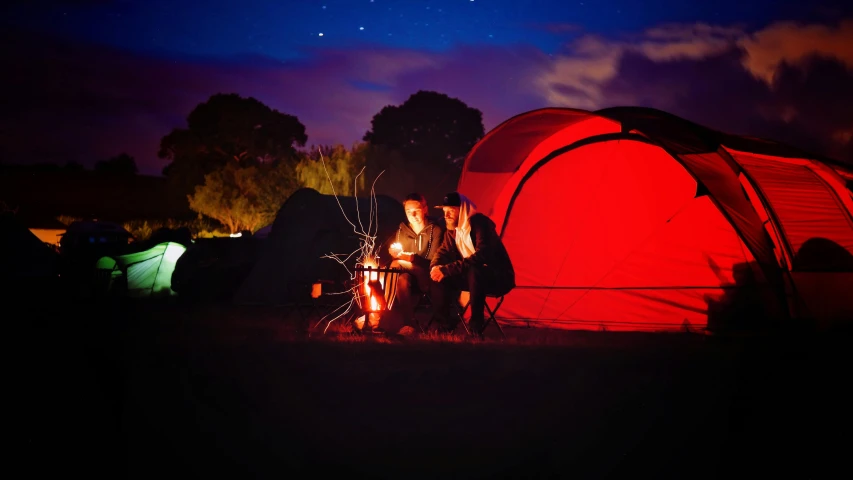 a group of people sitting around a campfire, by Julian Allen, pexels contest winner, romanticism, red rim light, tent, instagram post, australian winter night