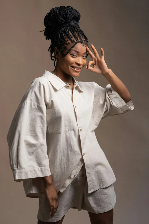 a woman posing in a white shirt and shorts, by Chinwe Chukwuogo-Roy, trending on pexels, renaissance, wearing a linen shirt, cropped shirt with jacket, studio photo, zendaya