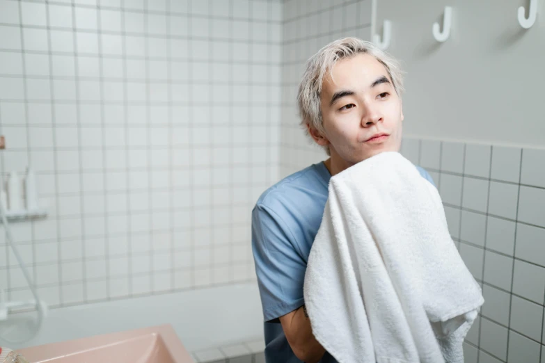 a man standing in a bathroom holding a towel, inspired by jeonseok lee, trending on pexels, shin hanga, short blue haired woman, flushed cheeks, aged 2 5, non-binary