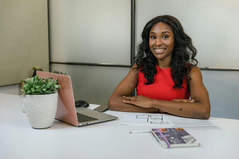 a woman sitting at a table with a laptop, mkbhd, avatar image