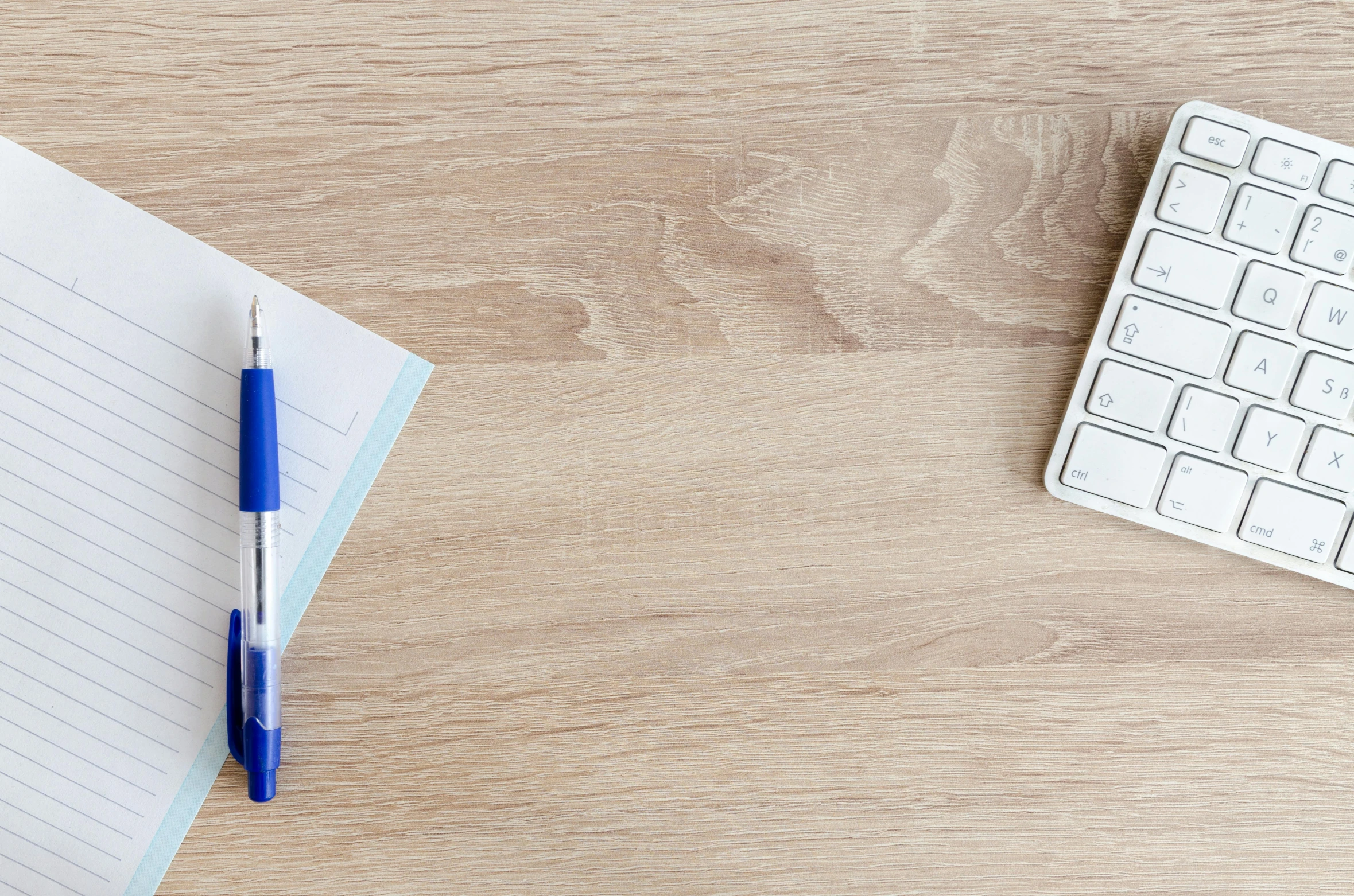 a blue pen sitting on top of a notebook next to a keyboard, trending on pexels, lacquered oak reception desk, background image, woody\'s homework, seen from straight above