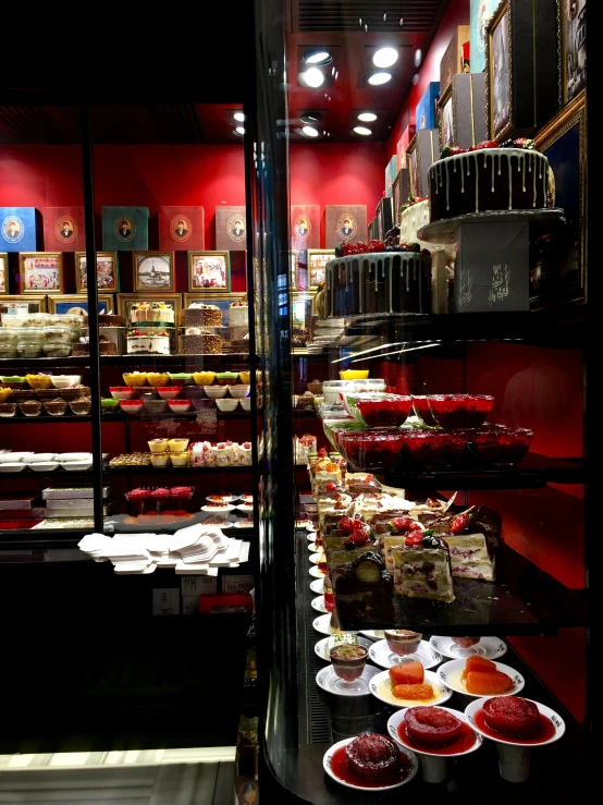 a store filled with lots of different types of food, by Julia Pishtar, art nouveau, black and red color scheme, desserts, panorama shot, royal