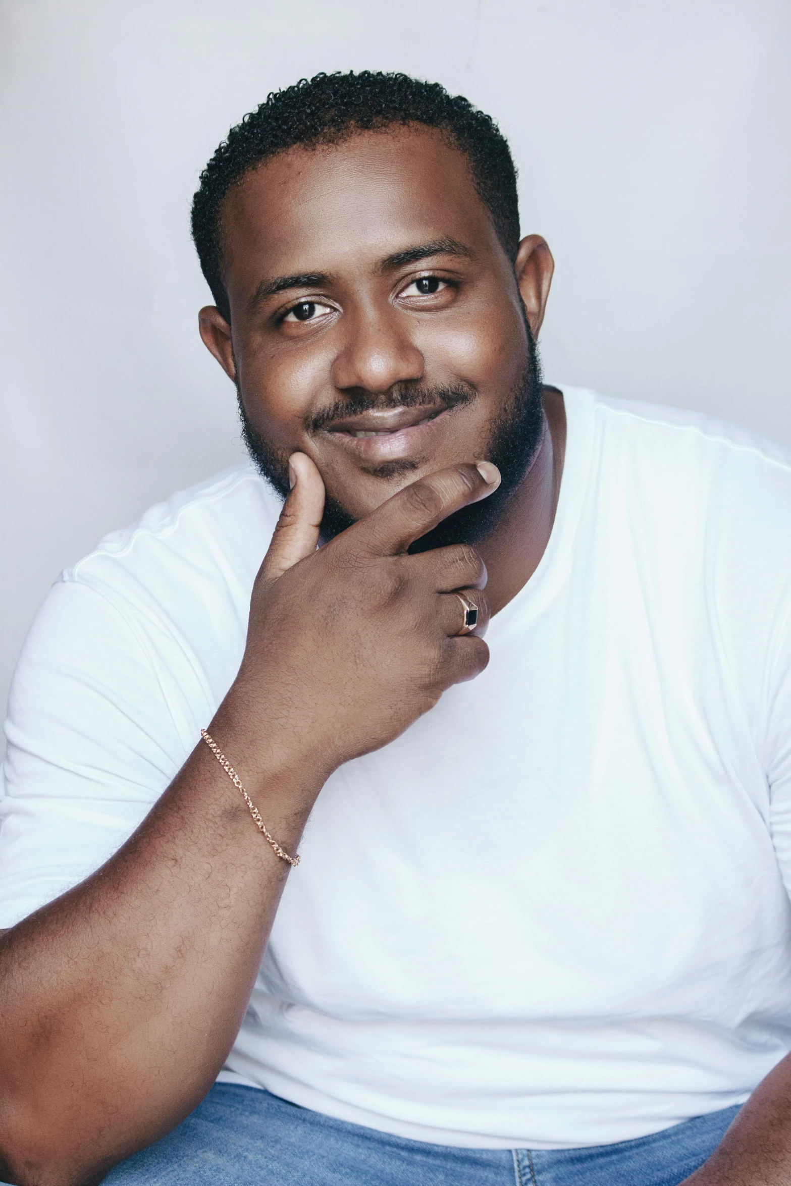 a man sitting down with his hand on his chin, an album cover, inspired by Theo Constanté, pexels contest winner, alluring plus sized model, large friendly eyes, headshot profile picture, vinayak