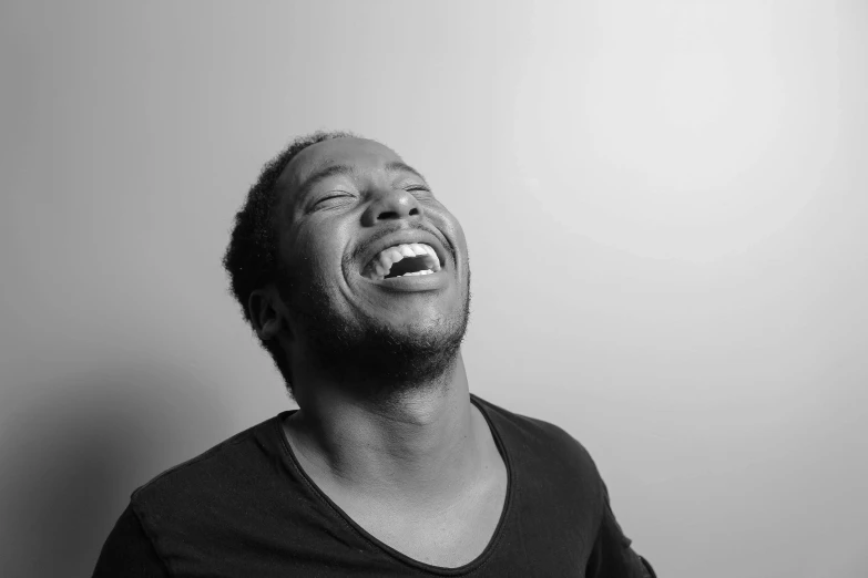 a black and white photo of a man laughing, by Matija Jama, uploaded, david uzochukwu, an artistic pose, jeffery smith