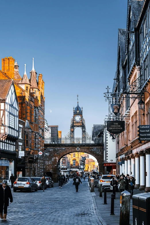 a group of people walking down a street next to tall buildings, renaissance, tudor architecture, manchester city, tall bridge with city on top, wrought iron architecture