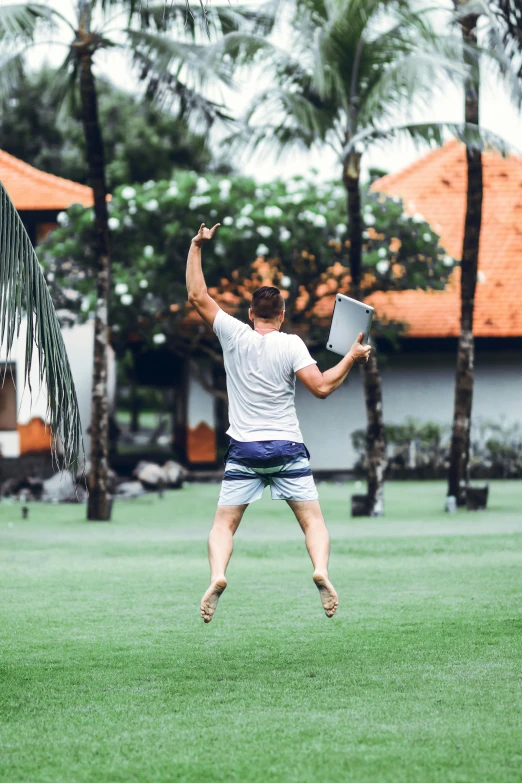 a man jumping in the air to catch a frisbee, happening, bali, lawns, instagram post, working out