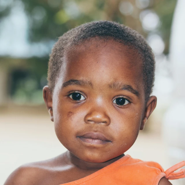 a close up of a child wearing an orange shirt, by Daniel Lieske, hurufiyya, portrait image, george pemba, 2 years old, 15081959 21121991 01012000 4k