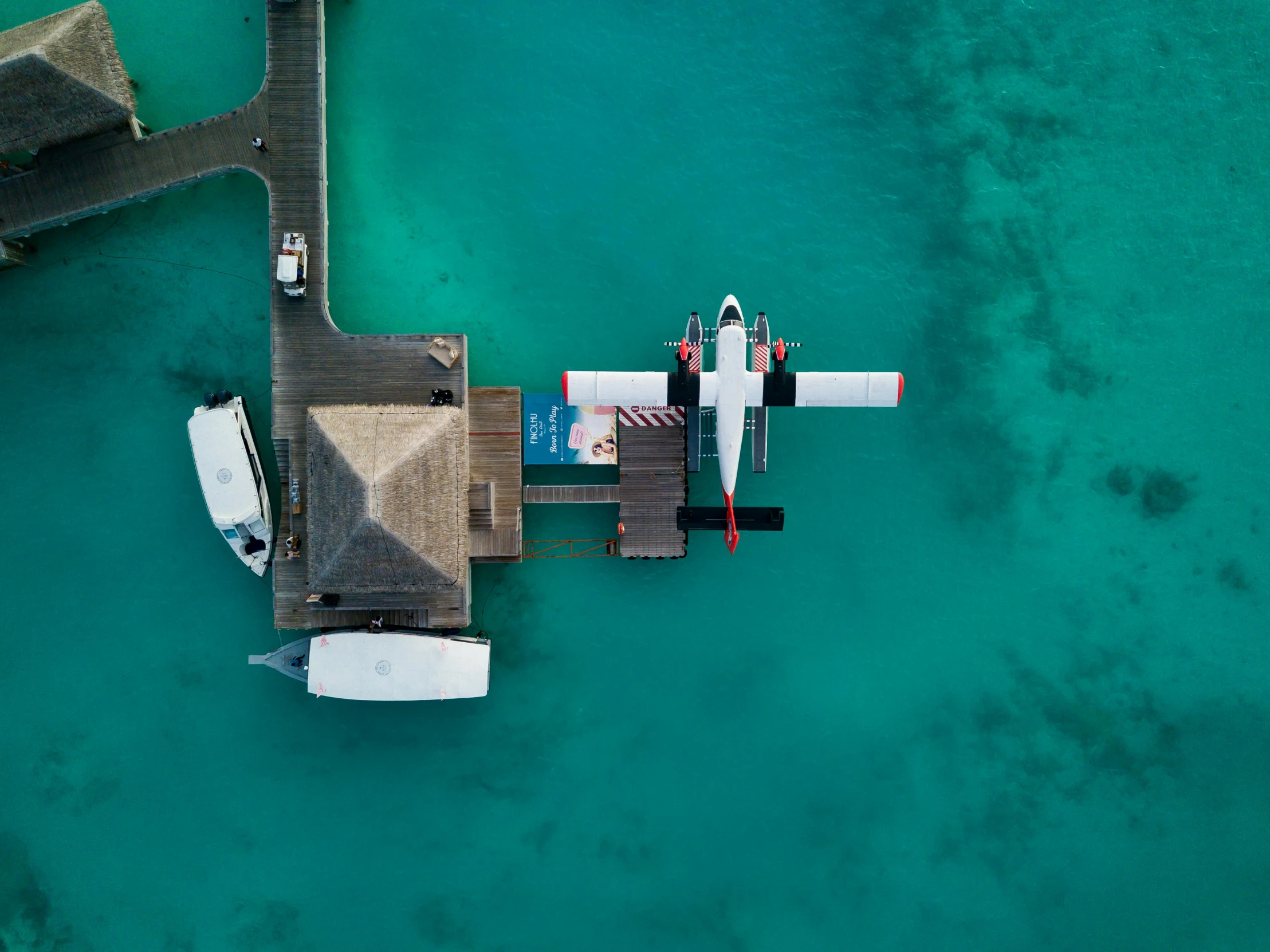 an aerial view of a boat docked at a pier, by Peter Churcher, pexels contest winner, hurufiyya, jets, underwater home, airplane view, paradise in the background