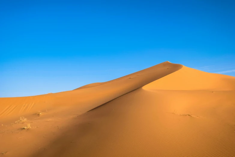 a large sand dune in the middle of a desert, pexels contest winner, les nabis, cloudless blue sky, lpoty, tuareg, an intricate