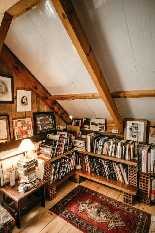 a room filled with lots of books and a lamp, a portrait, unsplash, arts and crafts movement, in an attic, chalet, picture frames, high - angle