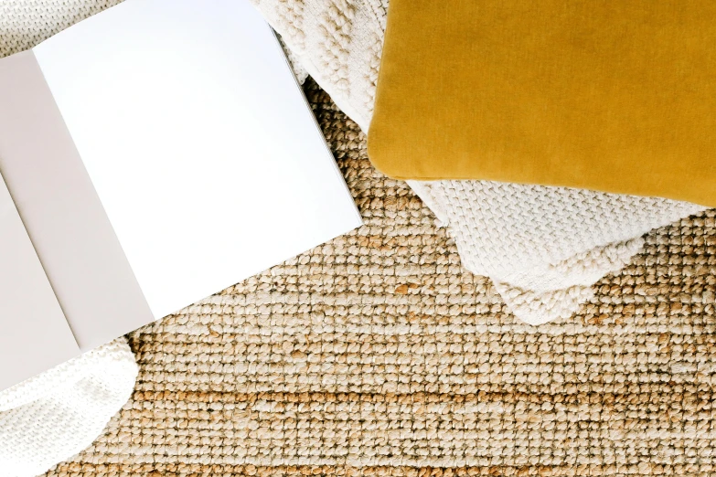 a laptop computer sitting on top of a rug, by Carey Morris, trending on unsplash, some sandy yellow pillows, different textures and materials, thumbnail, background image