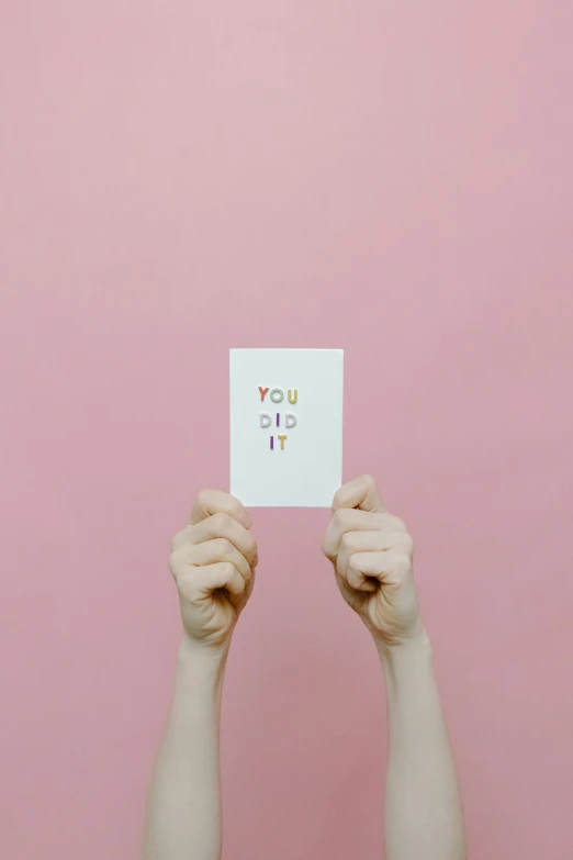 a person holding a piece of paper in front of their face, by Rachel Reckitt, trending on unsplash, postminimalism, birthday card, yolo, pink, ffffound