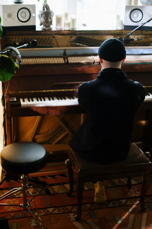 a man sitting at a piano in front of a window, backfacing, classic vibes, mechanics, promo image