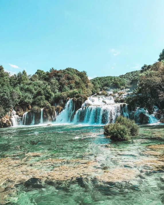 a waterfall in the middle of a lush green forest, unsplash contest winner, hurufiyya, white travertine terraces, 90s photo, panoramic, vibrant hues