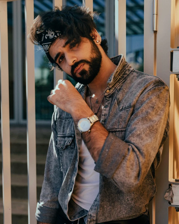 a man with a beard smoking a cigarette, an album cover, by Adam Dario Keel, trending on pexels, wears a watch, non binary model, middle eastern, ( ( ( wearing jeans ) ) )