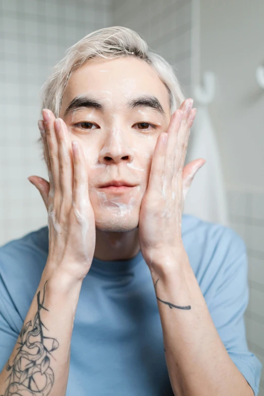 a man is shaving his face with his hands, inspired by jeonseok lee, reddit, non binary model, holding his hands up to his face, skincare, asian old skinny scientist