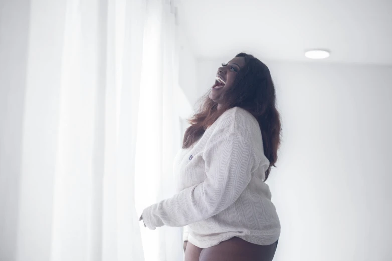 a woman that is standing in front of a window, manically laughing, curvy accentuated booty, in white room, dark skinned