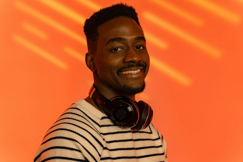 a close up of a person wearing headphones, by Stokely Webster, in front of an orange background, mkbhd, very slightly smiling, various posed