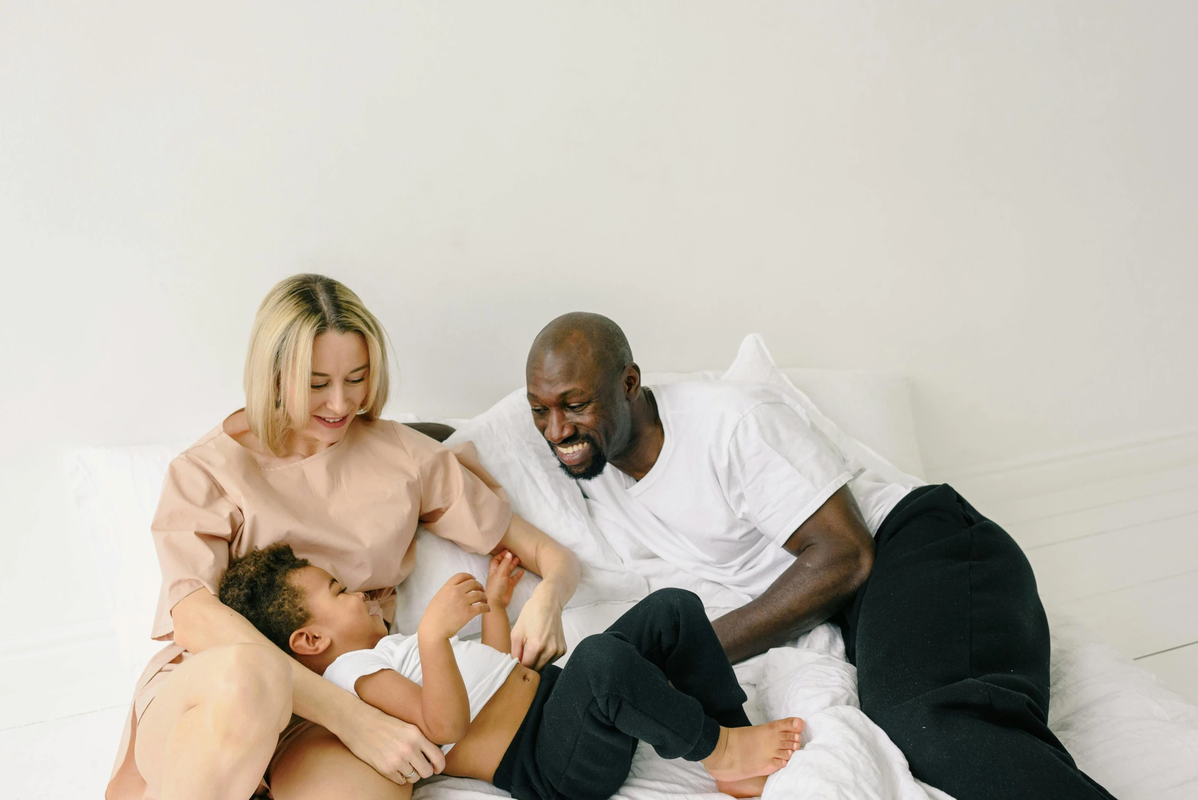 a group of people laying on top of a bed, by Carey Morris, pexels contest winner, husband wife and son, virgil abloh, gif, amicable