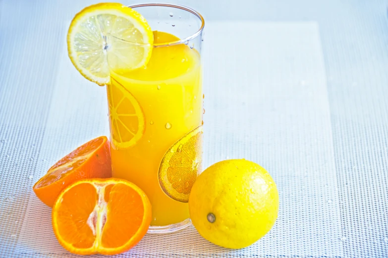 a glass of orange juice with a slice of lemon, by Carey Morris, pexels, 🦩🪐🐞👩🏻🦳, chartreuse and orange and cyan, thumbnail, bright daylight