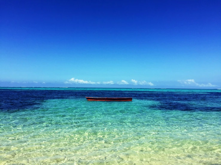 a boat floating on top of a body of water, hurufiyya, clear blue skies, beach setting, amazing colours, moana