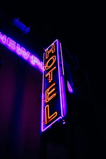 a neon sign hanging from the side of a building, by Niko Henrichon, pexels, happening, hotel room, ((purple)), multiple stories, nightclub