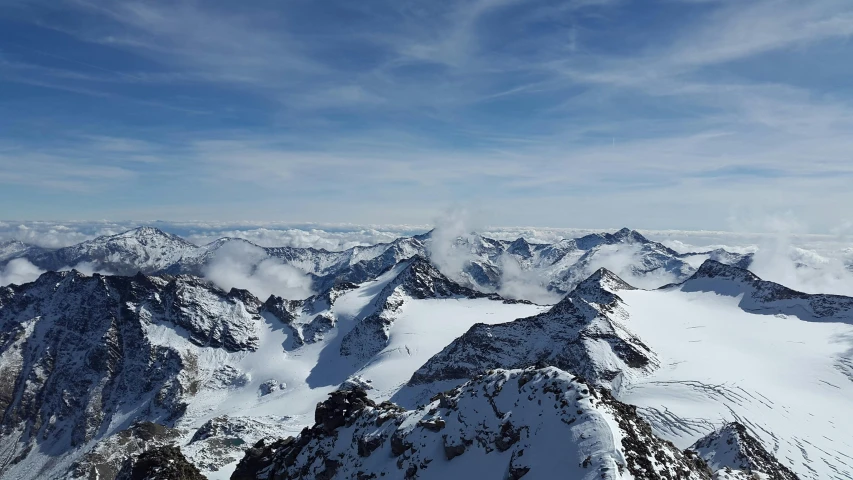 a person standing on top of a snow covered mountain, by Niko Henrichon, pexels contest winner, hurufiyya, view from the sky, highly detailed photo 4k, multiple stories, high resolution