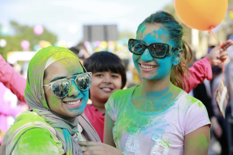 a couple of women standing next to each other, by Arabella Rankin, shutterstock, hurufiyya, fully covered in colorful paint, people enjoying the show, green colours, 5 k