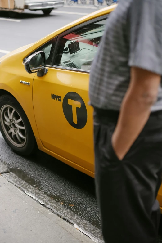 a yellow taxi cab sitting on the side of a road, happening, new york times, man standing, zoomed in, 🚿🗝📝