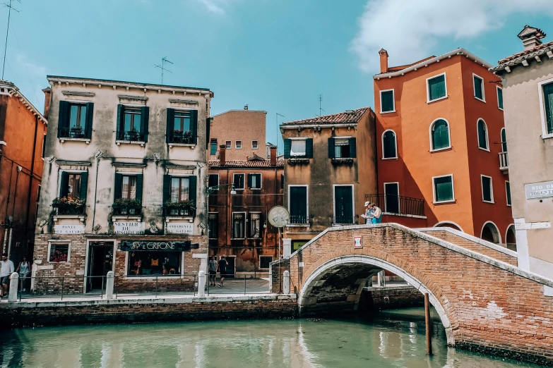 a bridge over a body of water next to buildings, pexels contest winner, renaissance, olive green and venetian red, 🦩🪐🐞👩🏻🦳, whitewashed buildings, youtube thumbnail