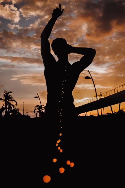 a silhouette of a man throwing a frisbee at sunset, a statue, inspired by Rodel Gonzalez, kinetic art, 2019 trending photo, puerto rico, hanging out with orbs, ((sunset))