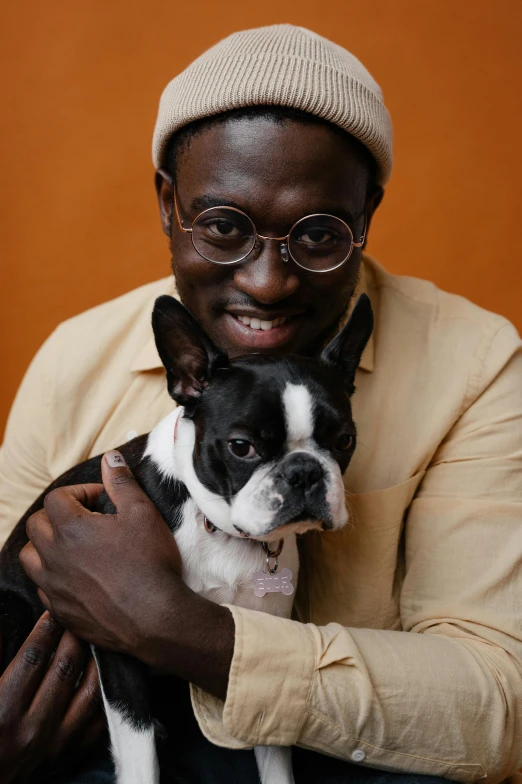 a close up of a person holding a dog, trending on unsplash, renaissance, man is with black skin, spectacled, french bulldog, brown:-2